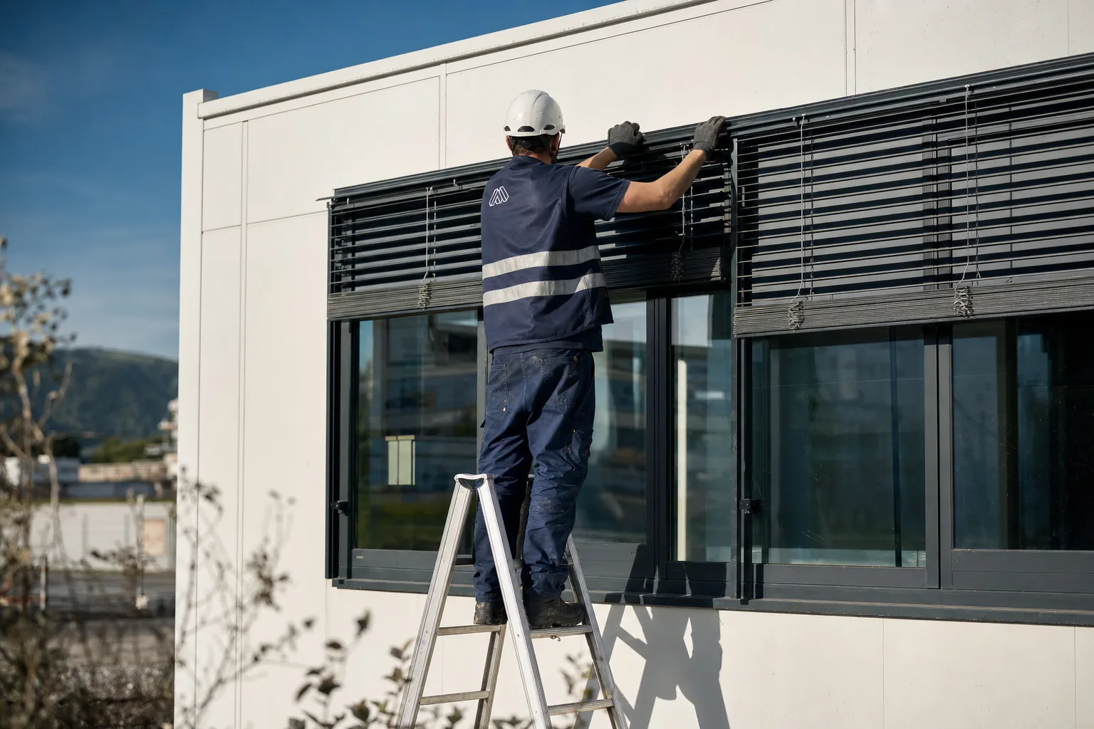 Monteur prüft einen Raffstore an einem Containerbüro