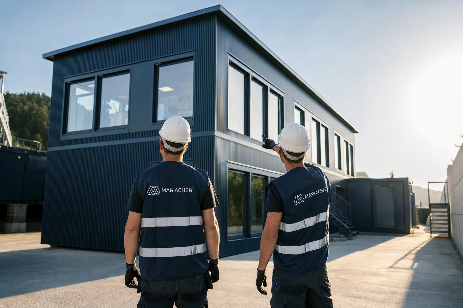Two Mariacher fitters looking at a completed modular building on the works site