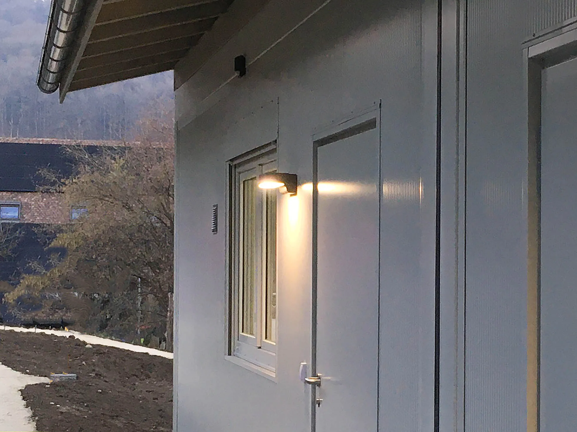 Fassadendetail mit Aussenleuchte und Fenster an der Sozialunterkunft Niederweningen