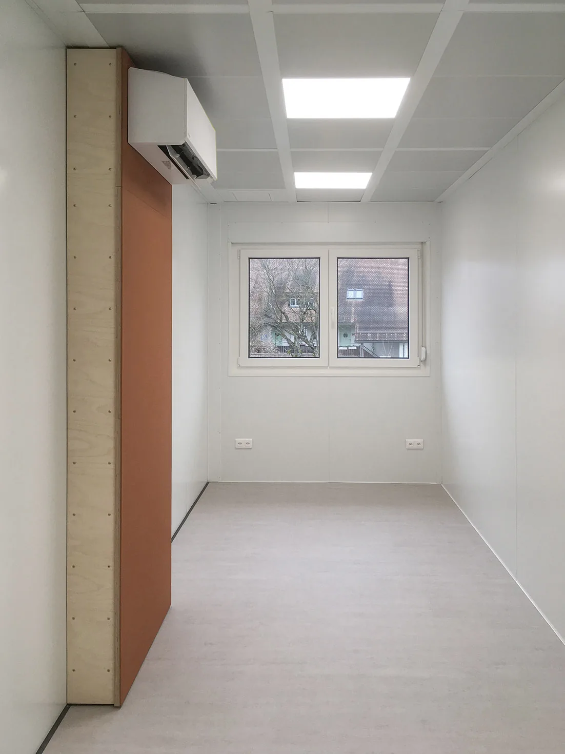 Zimmer mit Fenster und Einbauschrank in der Sozialunterkunft Niederweningen