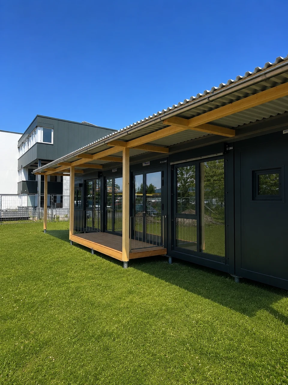 Holzterrasse mit Stützen entlang der Fassade der Kindertagesstätte Basel