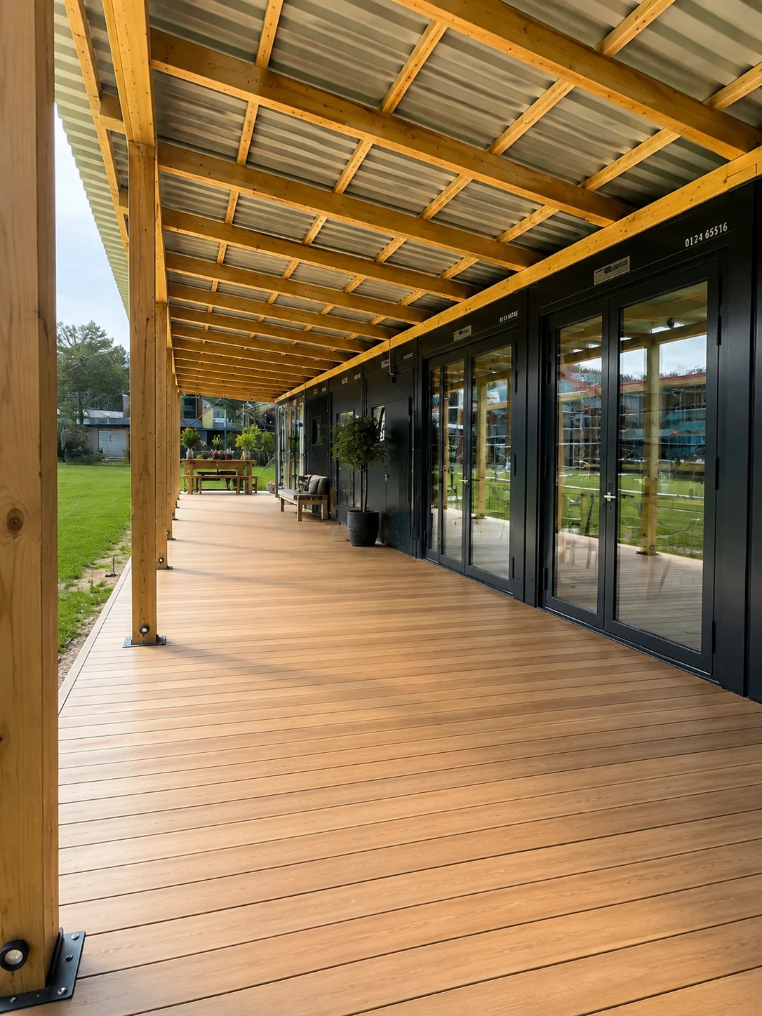 Überdachte Holzveranda entlang der Mitarbeiterunterkunft mit Kantine in Luzern